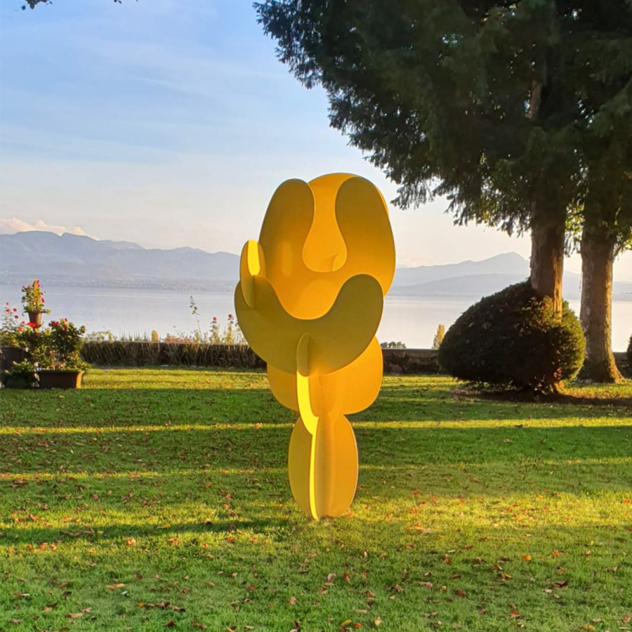 Objet Stellaire Mercurian by philippe cramer Yellow scuplture in a garden overlooking a lake